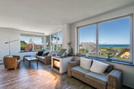 Kaminzimmer mit Meerblick, das Feuer im Kamin schafft anheimelnde Stimmung